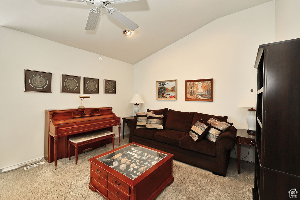 Living area with lofted ceiling, ceiling fan, and light colored carpet