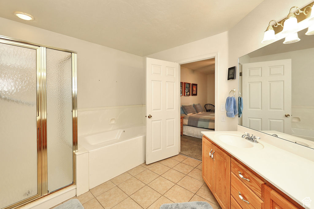 Bathroom featuring a garden tub, vanity, tile patterned flooring, a shower stall, and connected bathroom