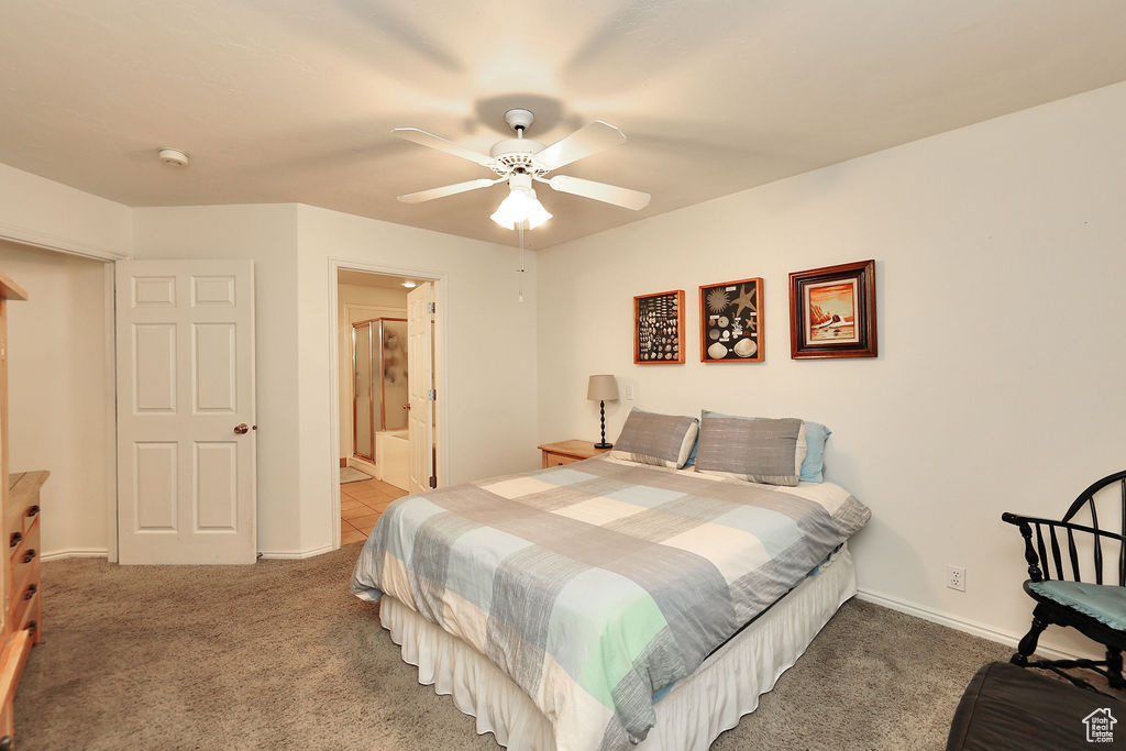Bedroom with carpet flooring, a ceiling fan, and connected bathroom
