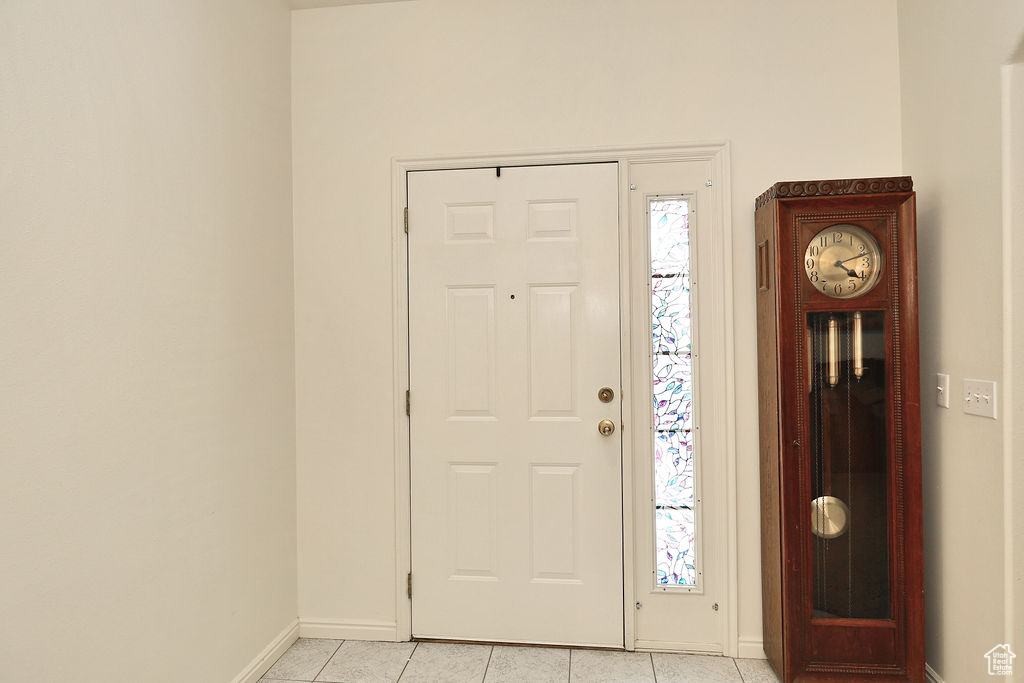 Foyer with baseboards and light tile patterned flooring