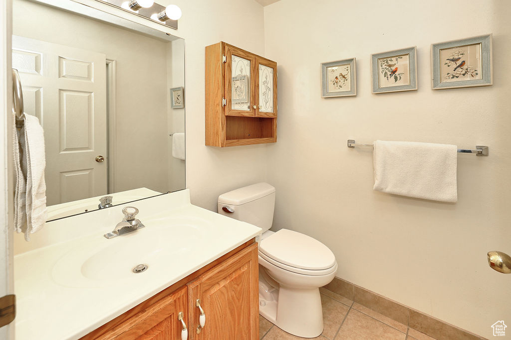 Half bathroom featuring tile patterned floors and vanity