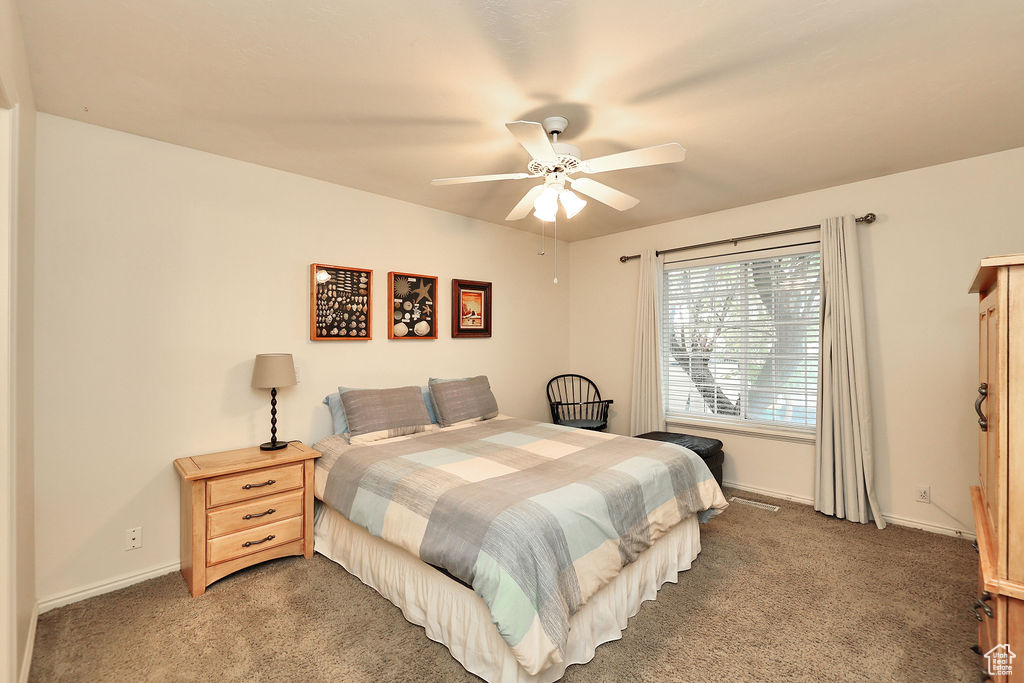 Carpeted bedroom featuring baseboards and ceiling fan