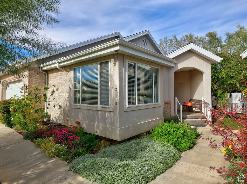 View of side of property featuring stucco siding and an attached garage