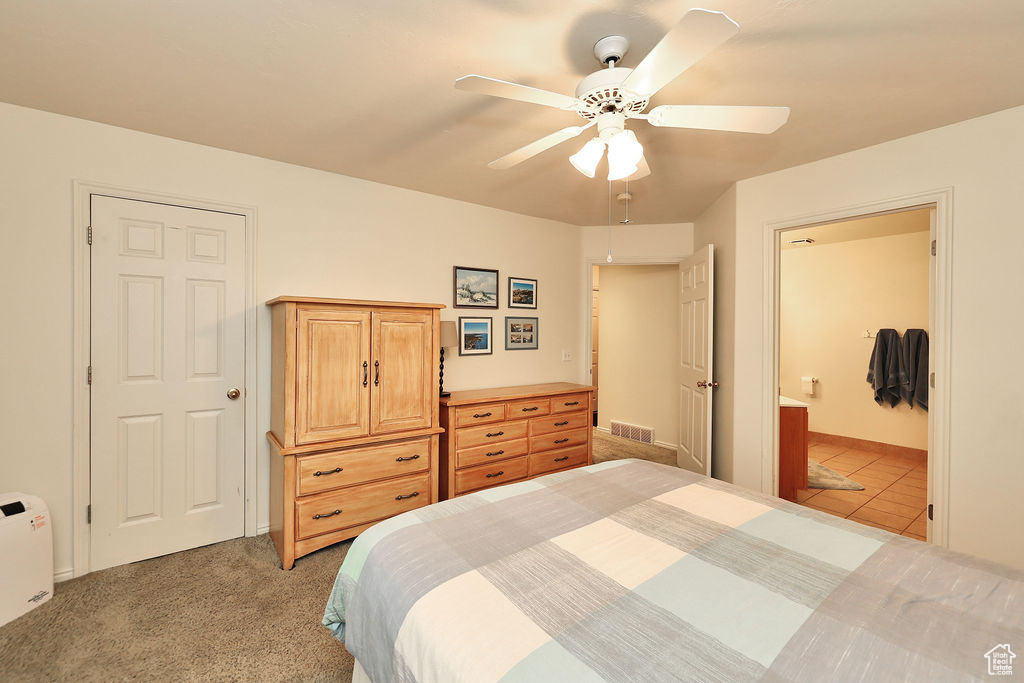 Bedroom with ceiling fan, carpet flooring, and ensuite bathroom