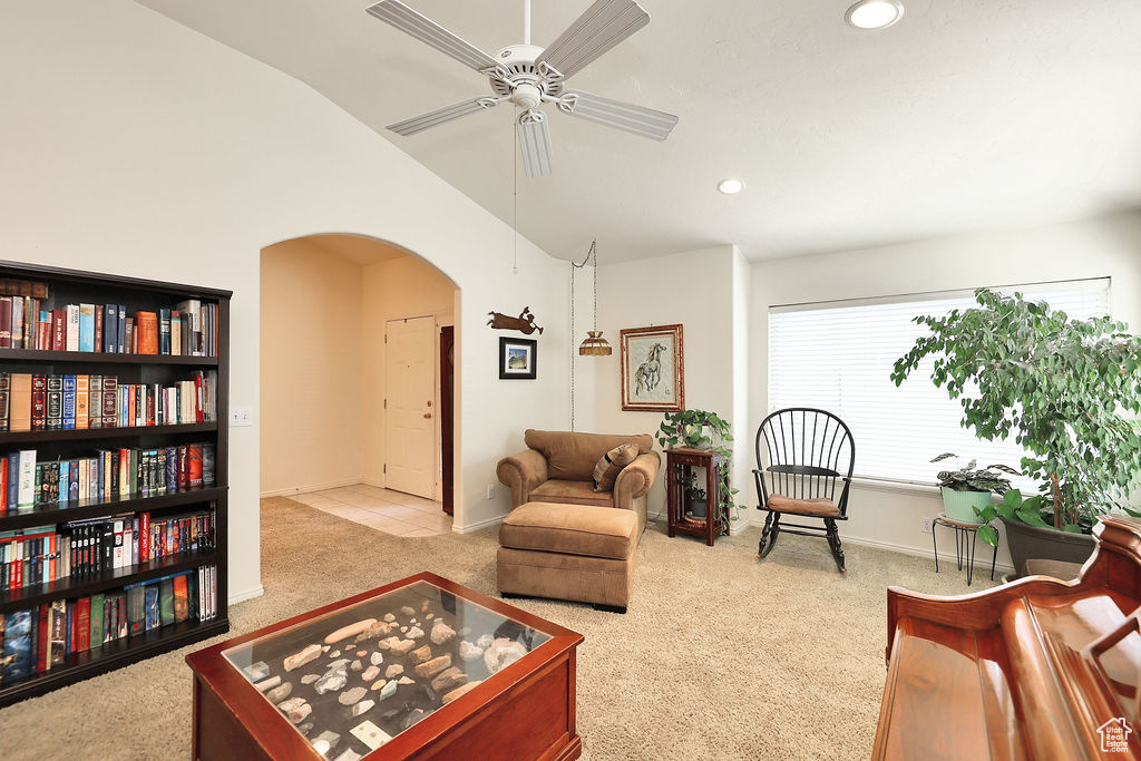 Carpeted living room with arched walkways, vaulted ceiling, a ceiling fan, and recessed lighting
