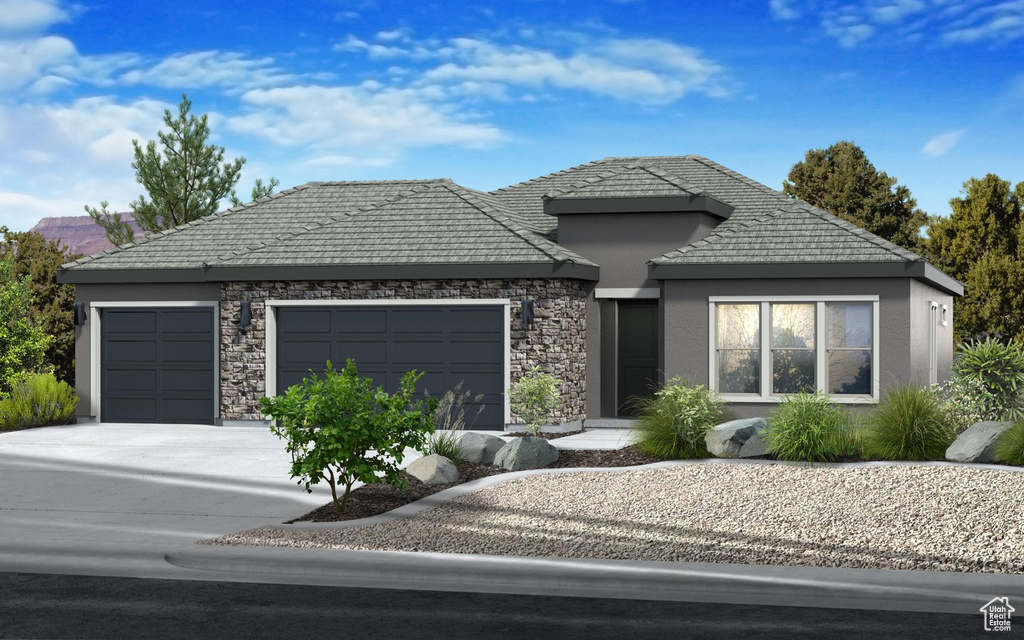 View of front of house featuring a garage, stone siding, stucco siding, and driveway