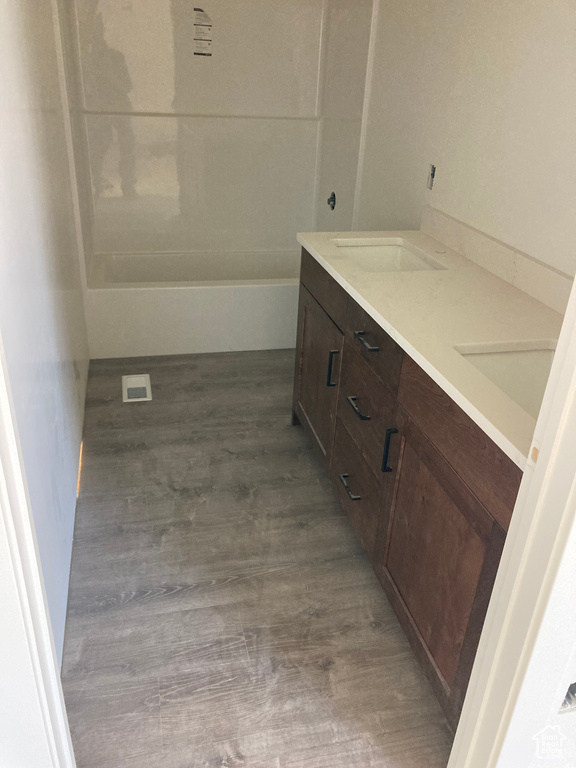 Full bathroom with double vanity and wood finished floors