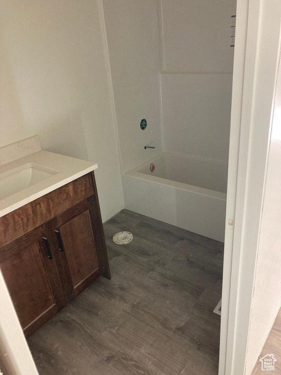 Bathroom with vanity, wood finished floors, and bathing tub / shower combination