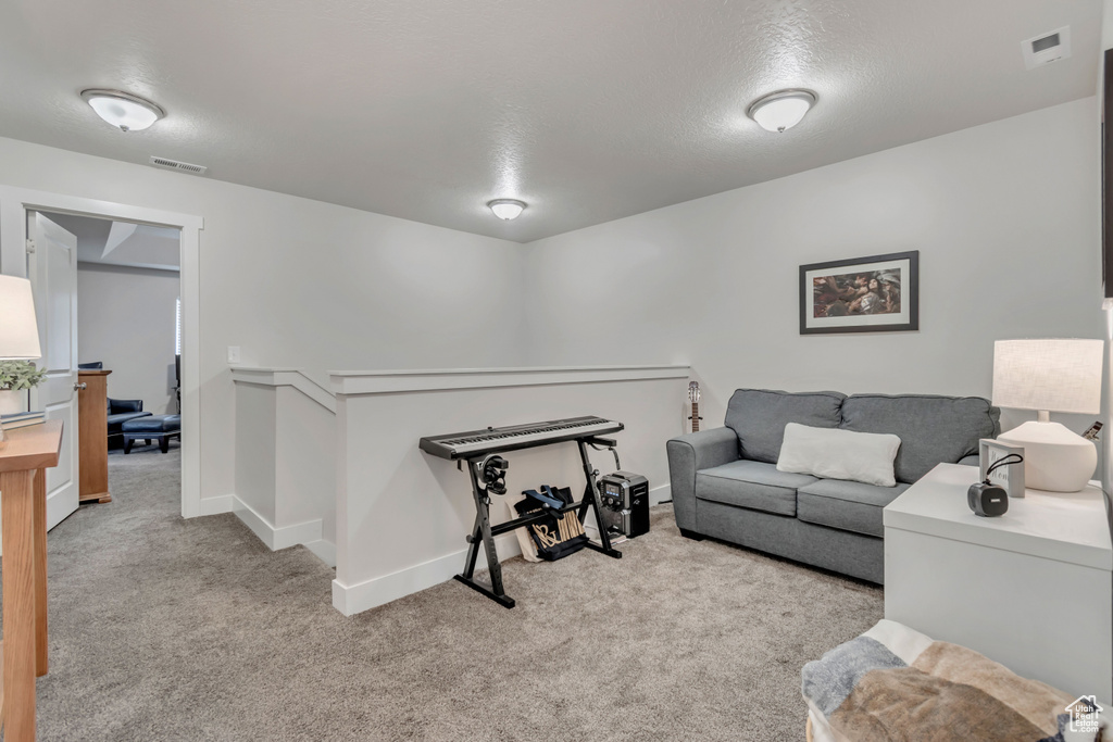 Living area featuring carpet flooring and baseboards