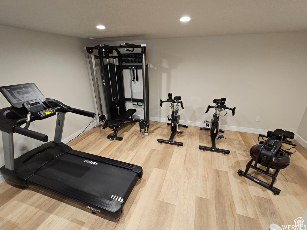 Workout area featuring wood finished floors and recessed lighting