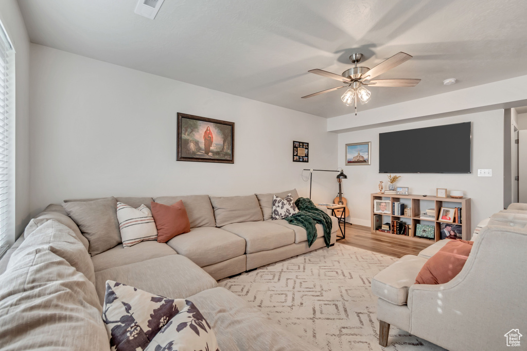 Living area with wood finished floors and ceiling fan