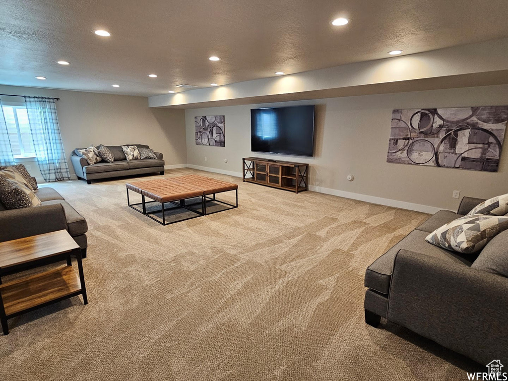 Living room with carpet floors, recessed lighting, and a textured ceiling
