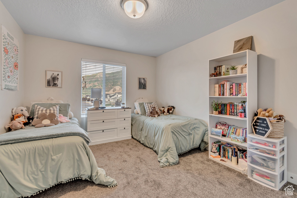 Bedroom with light carpet and a textured ceiling