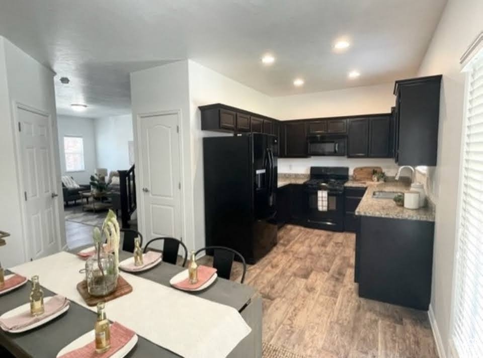 Kitchen featuring black appliances, light wood finished floors, and recessed lighting