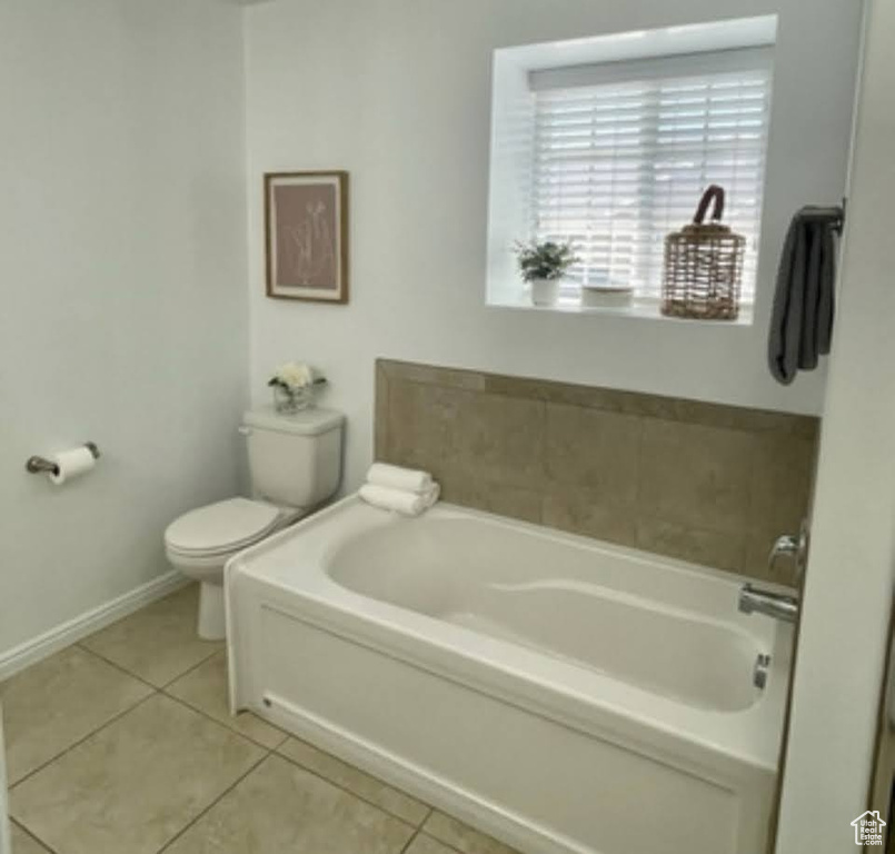 Full bathroom featuring a bath and tile patterned flooring