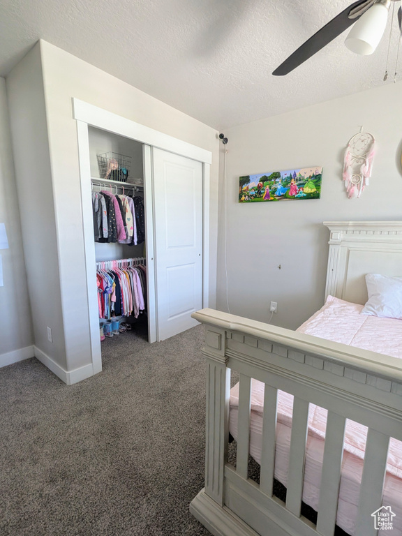 Carpeted bedroom with a closet, a textured ceiling, and ceiling fan