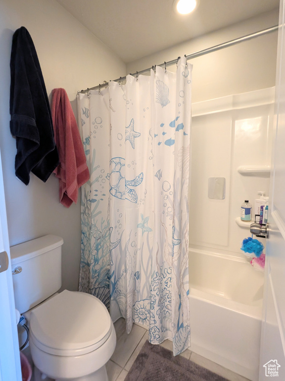 Full bath with shower / bath combo and tile patterned flooring