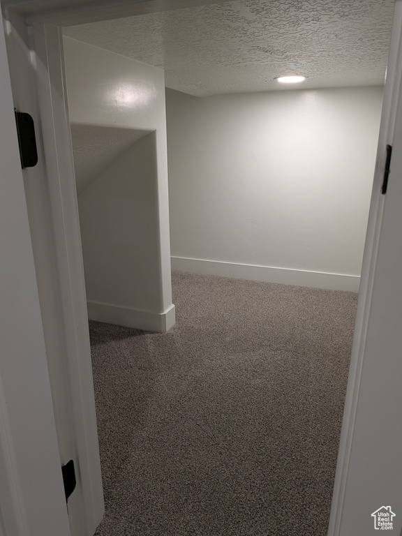 Empty room with carpet flooring and a textured ceiling