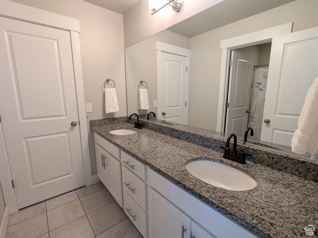 Bathroom with double vanity and tile patterned flooring