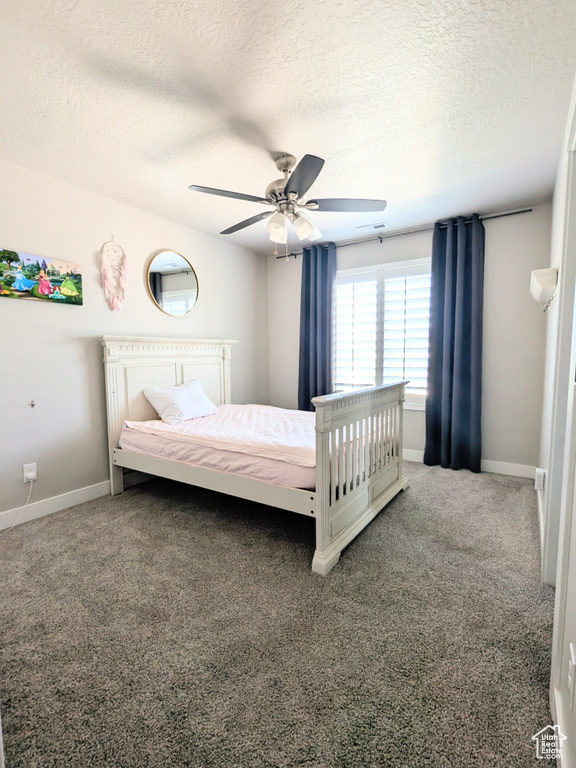 Carpeted bedroom with a textured ceiling and a ceiling fan