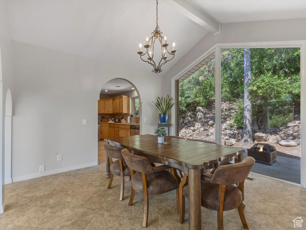 Dining room featuring arched walkways and a chandelier