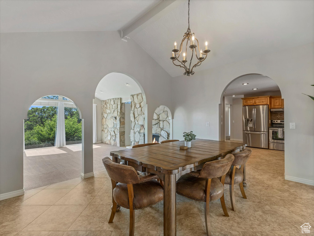 Dining area featuring arched walkways, a chandelier, high vaulted ceiling, light tile patterned floors, and beamed ceiling