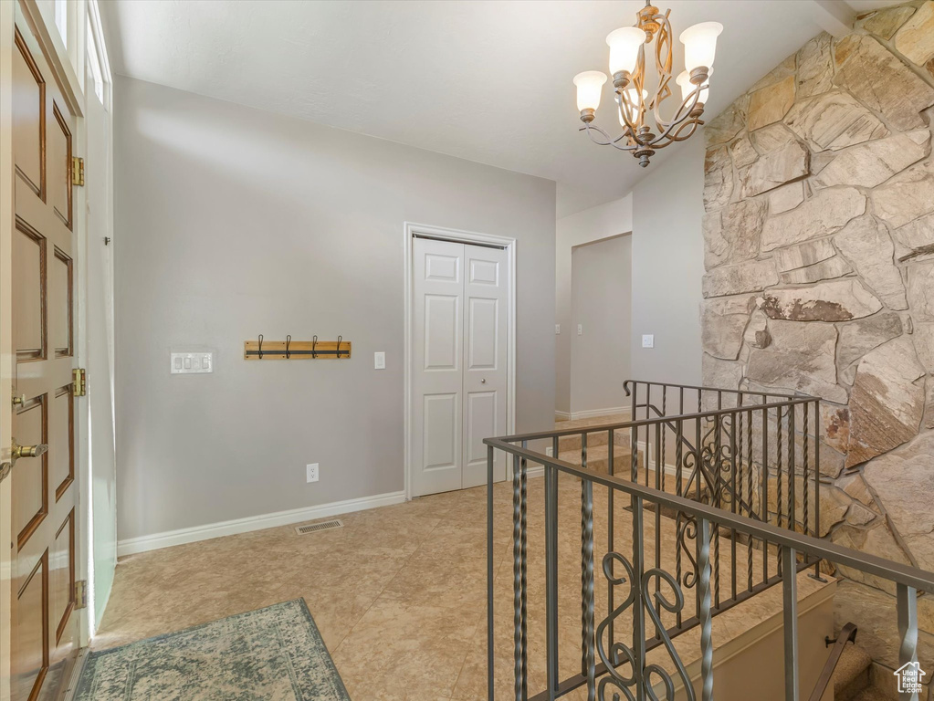 Hallway featuring an upstairs landing and a chandelier