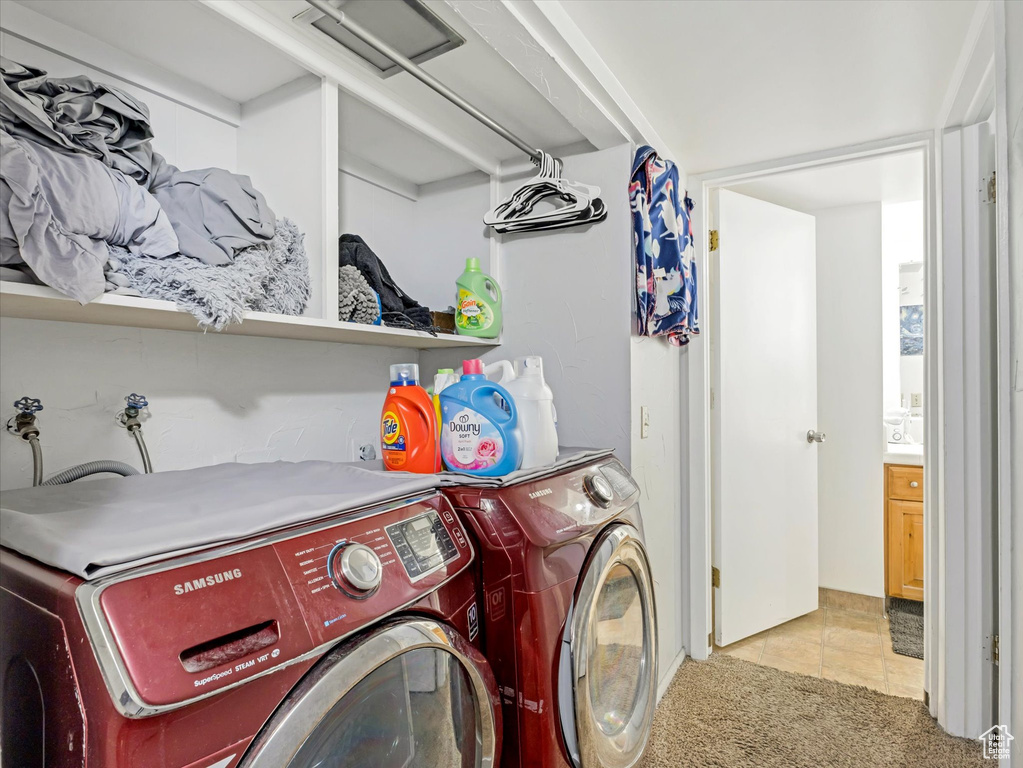Washroom with separate washer and dryer, light tile patterned flooring, and light carpet