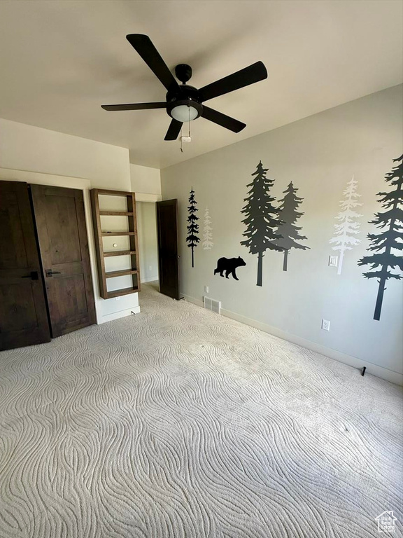 Unfurnished bedroom with carpet flooring and a ceiling fan