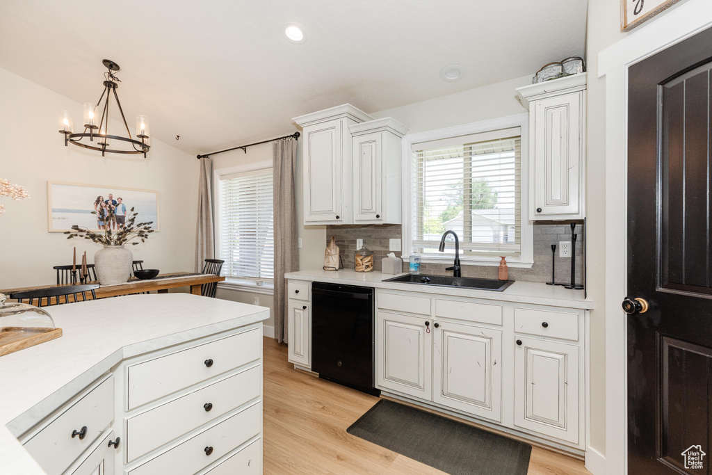 Kitchen with dishwasher, a chandelier, tasteful backsplash, light wood-style flooring, and recessed lighting