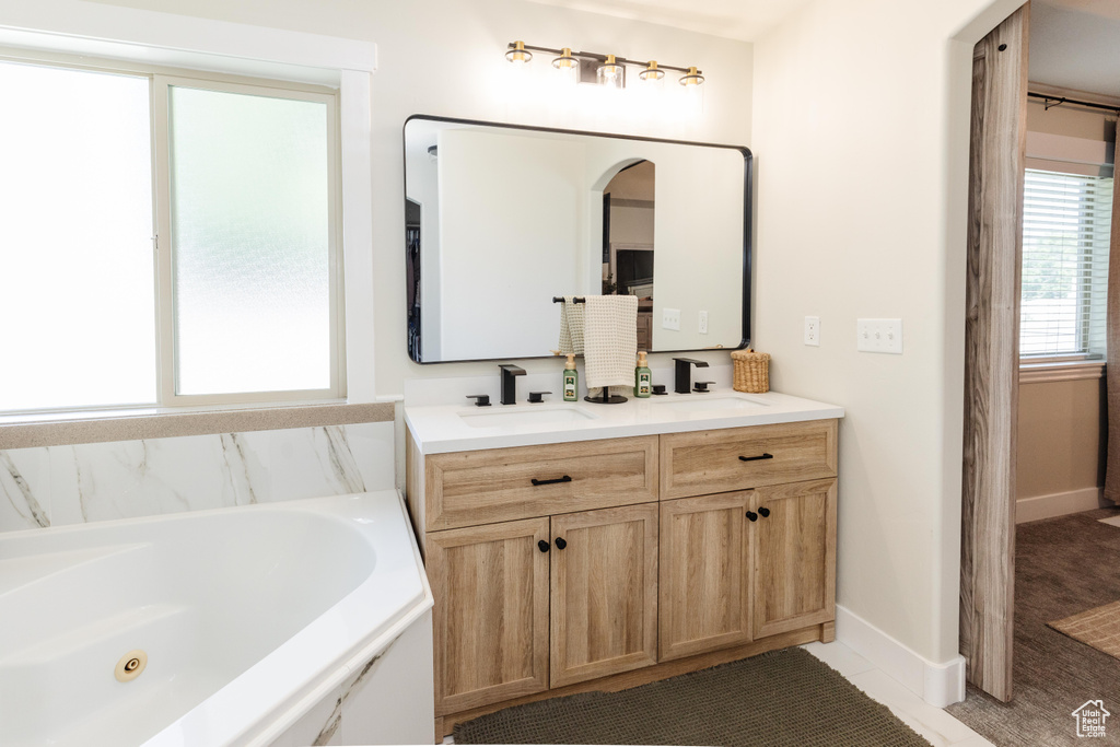 Bathroom featuring double vanity and a jetted tub