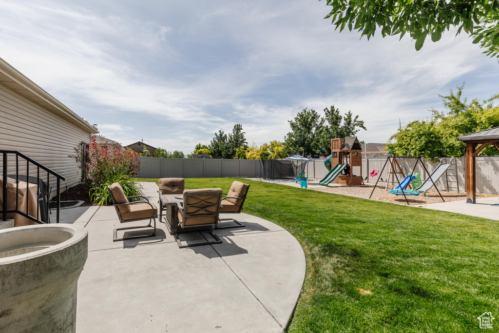 Fenced backyard with a playground and a patio