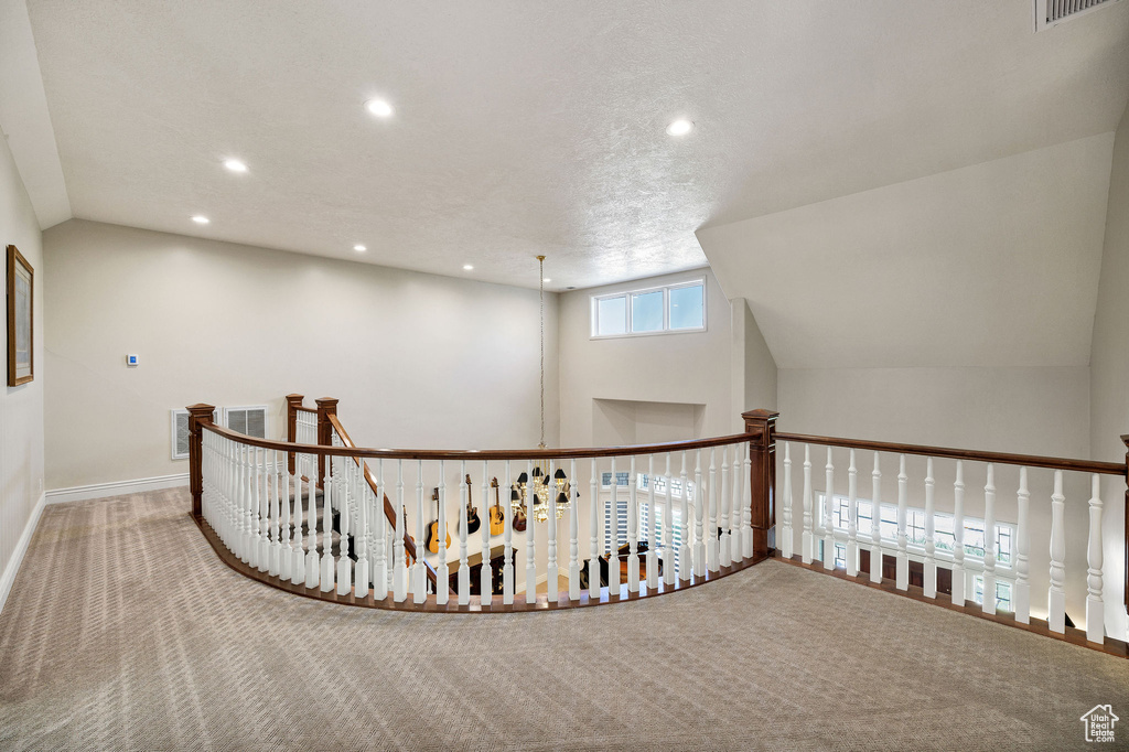 Hallway featuring carpet floors, recessed lighting, an upstairs landing, and lofted ceiling
