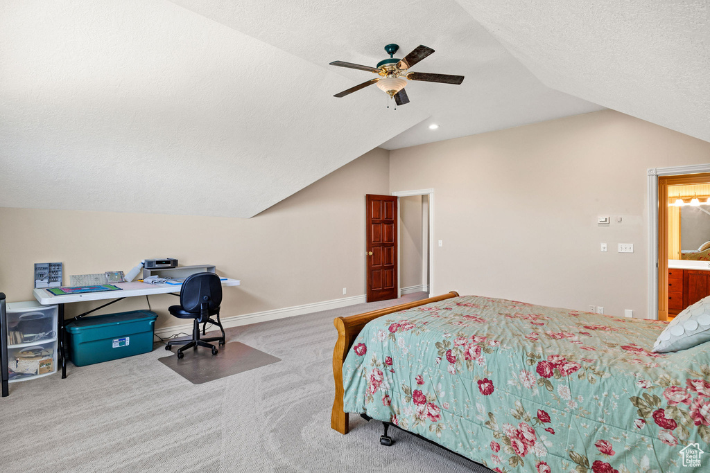 Bedroom featuring vaulted ceiling, carpet, a ceiling fan, a textured ceiling, and an office area