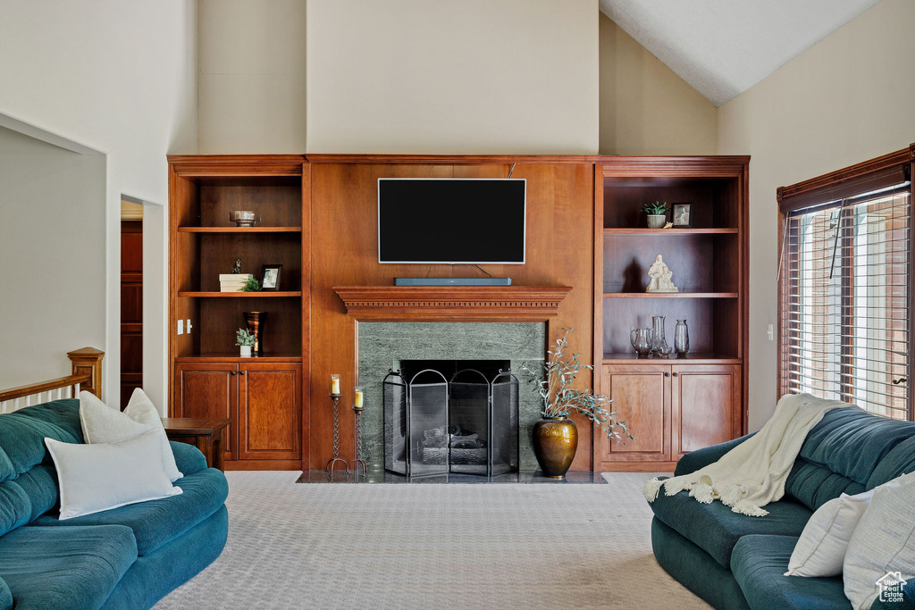 Carpeted living area featuring high vaulted ceiling and a high end fireplace