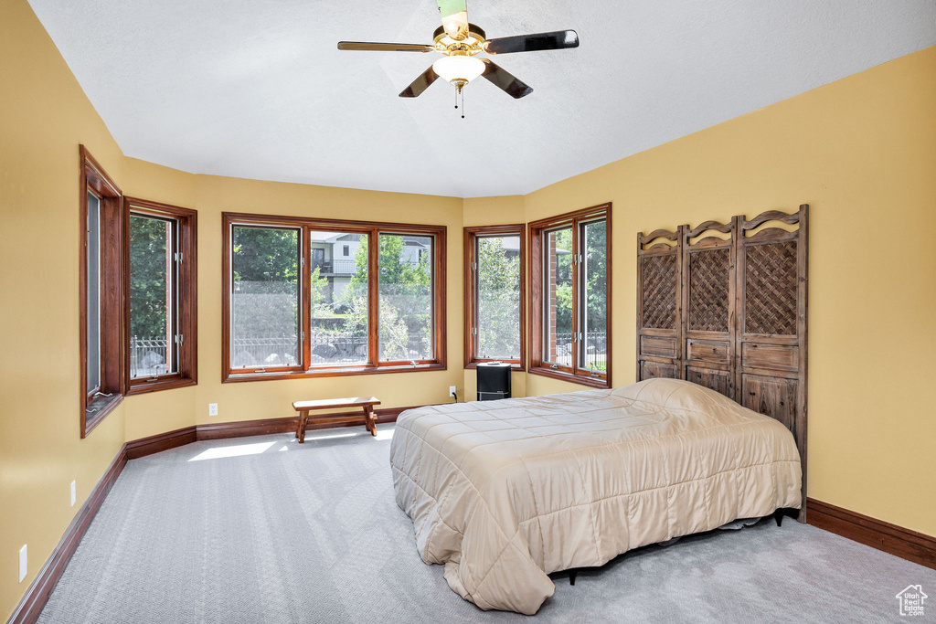 Carpeted bedroom featuring baseboards and a ceiling fan