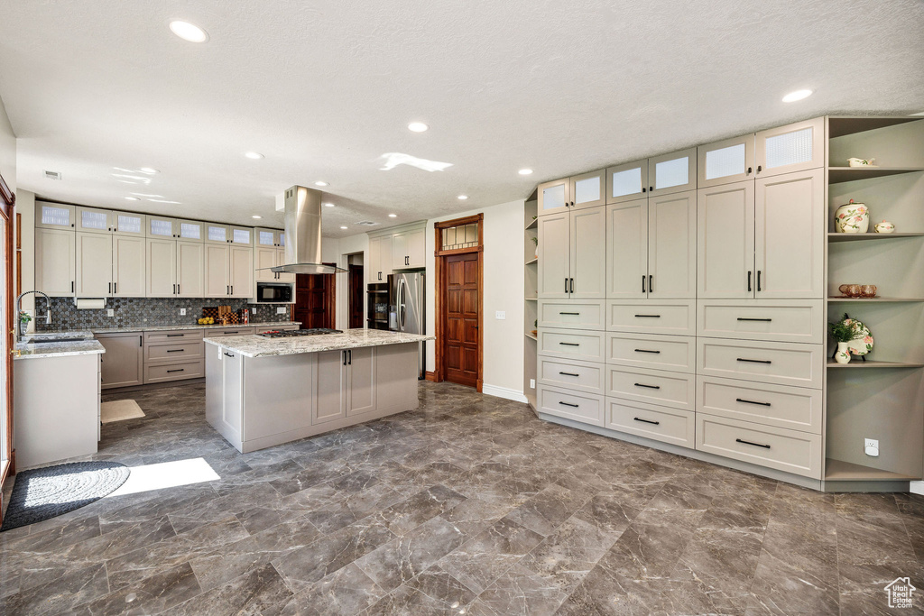Kitchen with island exhaust hood, appliances with stainless steel finishes, open shelves, a center island, and recessed lighting
