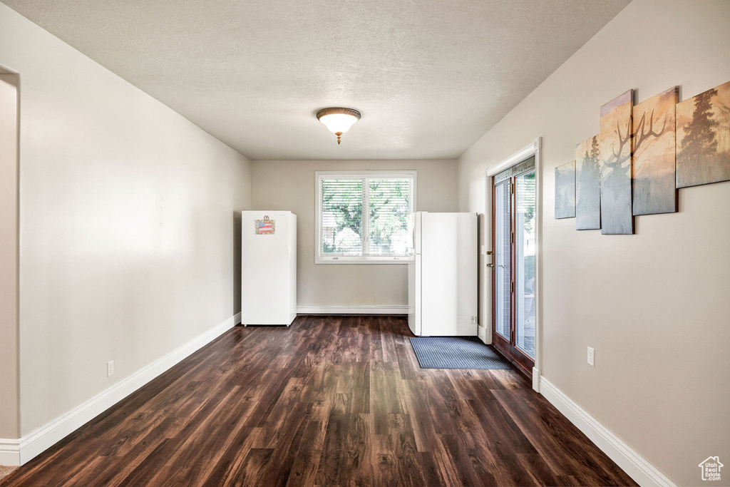 Unfurnished room with dark wood finished floors and a textured ceiling