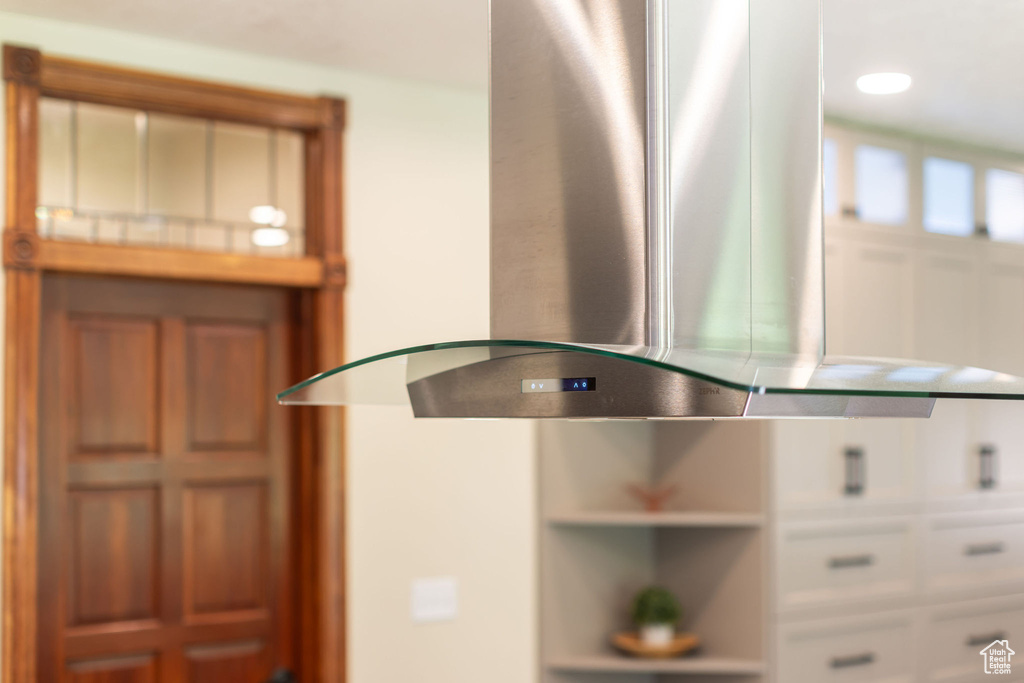 Kitchen view of island exhaust hood and white cabinets