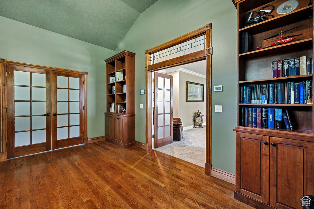 Interior space featuring french doors, lofted ceiling, and wood finished floors
