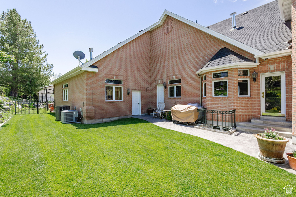 Back of house with a patio, brick siding, entry steps, and roof with shingles