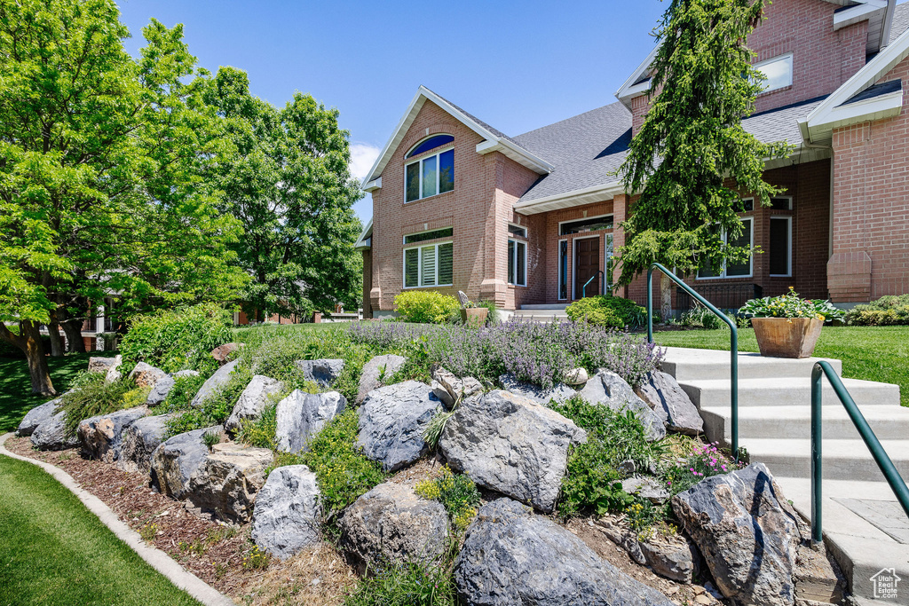 View of front of house with brick siding and a shingled roof