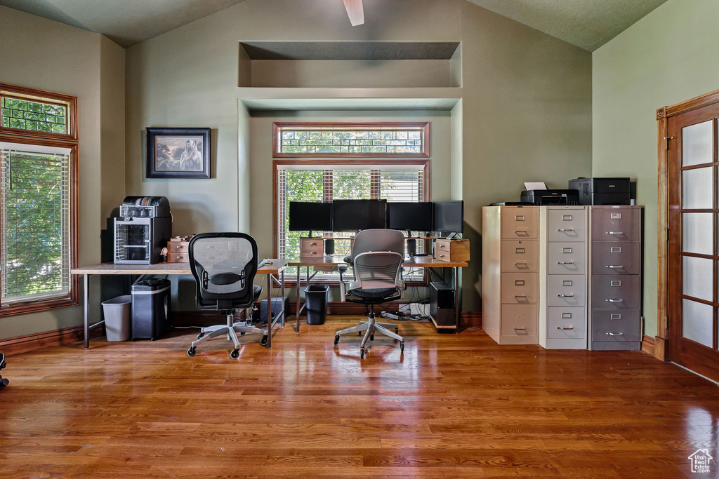 Office space featuring vaulted ceiling, wood finished floors, and plenty of natural light