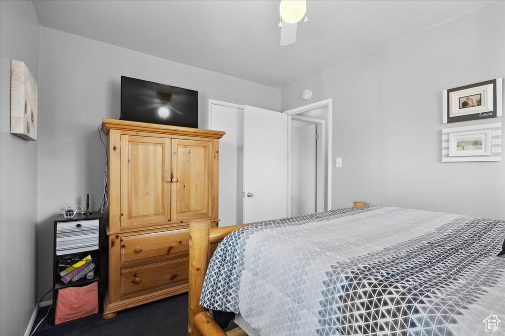 Bedroom with a ceiling fan and dark carpet
