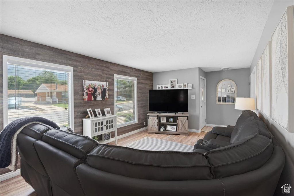Living area with light wood-type flooring and a textured ceiling