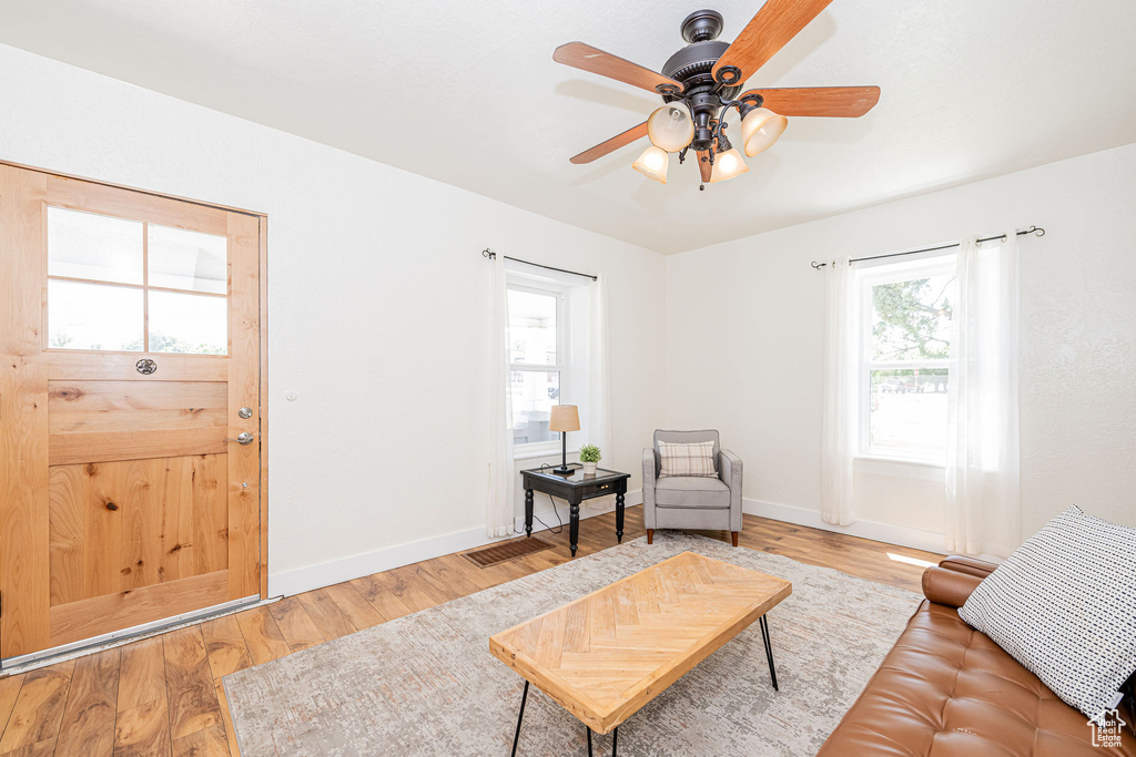 Living area with ceiling fan and wood finished floors