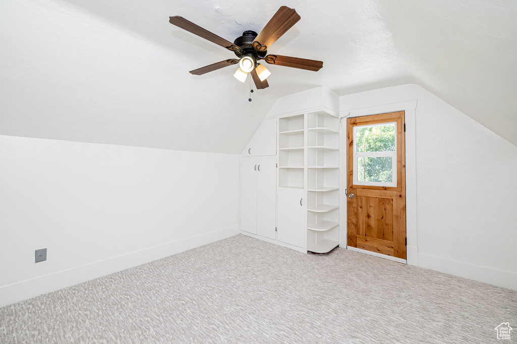 Bonus room with lofted ceiling, carpet flooring, and a ceiling fan
