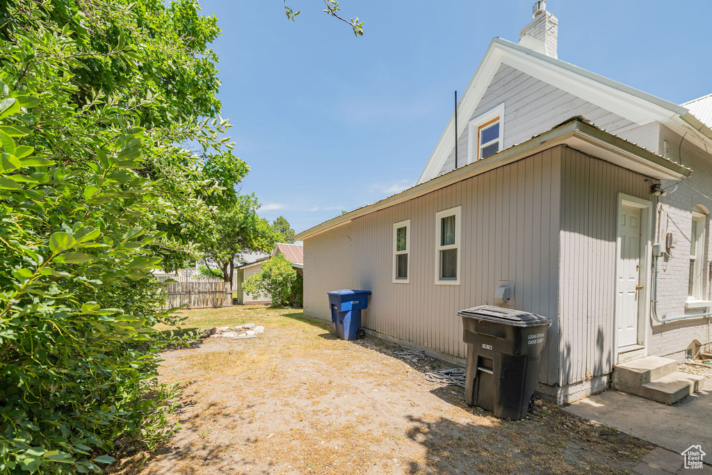 View of home\'s exterior featuring entry steps, a chimney, and a metal roof