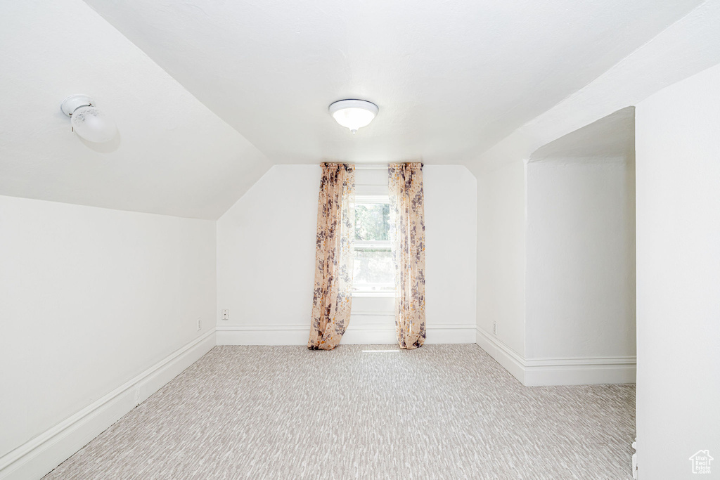 Bonus room with carpet flooring and lofted ceiling