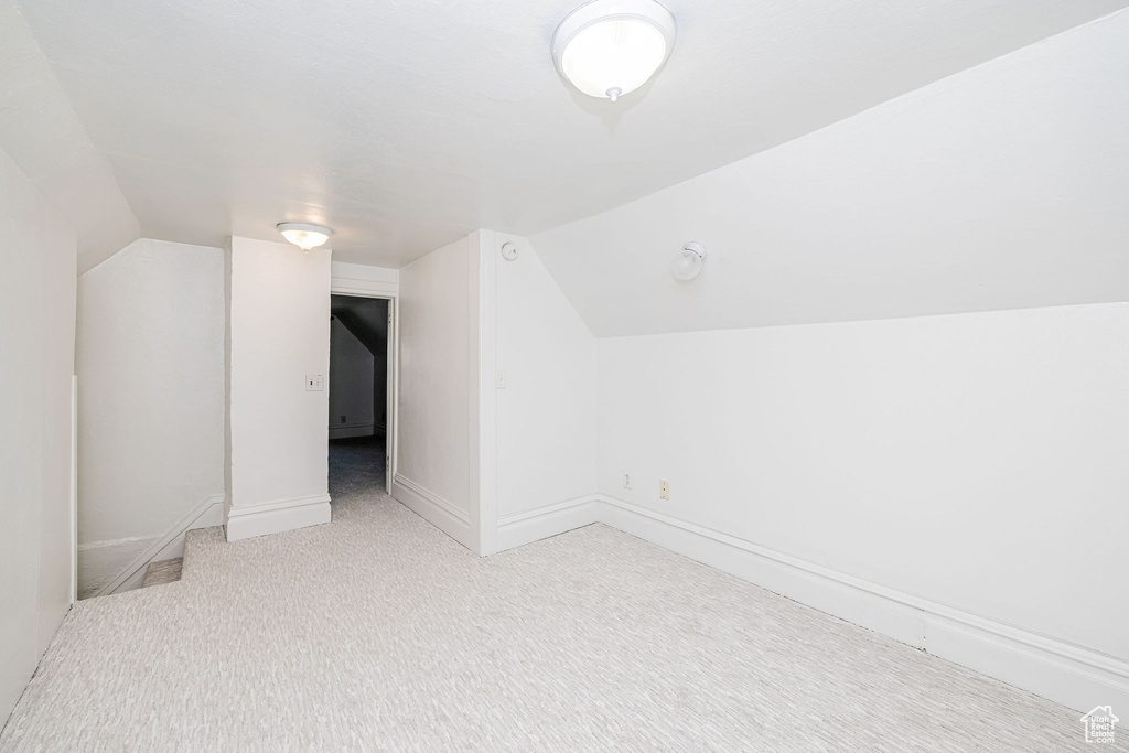 Bonus room featuring vaulted ceiling and carpet floors
